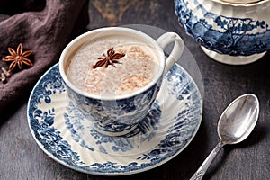 Masala tea chai latte traditional warm Indian sweet milk with spiced ingridients, cinnamon stick, ginger, herbs, spices