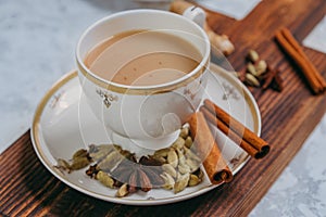 Masala tea. Flavoured tea chai. Traditional Indian hot drink with various spices on a wooden board in a porcelain mug