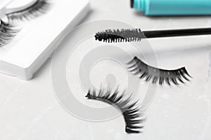 Mascara brush and false eyelashes on table