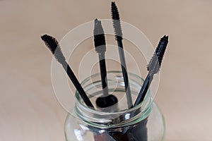Mascara brushes in a glass jar