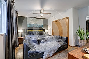 Masculine bedroom features gray accent wall