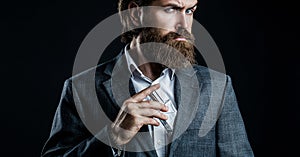 Masculine perfume, bearded man in a suit. Male holding up bottle of perfume. Perfume or cologne bottle and perfumery
