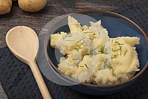 Mash potatoes with a wooden spoon