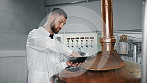 mash tun in modern brewery, technologist is checking malt grains