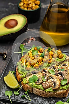 Mashed avocado, mushrooms and chickpea toasts. Delicious breakfast or snack, Clean eating, dieting, vegan food concept. top view