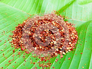 Mashed dried red hot chili on green banana leaf, Food ingredient for spicy recipe.