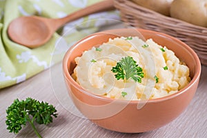 Mashed potato in bowl and fresh potatoes in basket photo