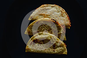 Mashed Potato and Chorizo Tacos Dorados on Black Background photo