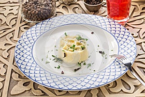 Mashed potato with dill and glass of red drink on orienral wooden table