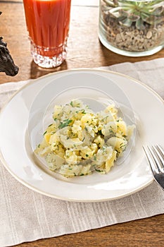 Mashed potato with dill with tomato juice on wooden table