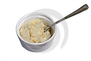 Mashed potato dish with spoon on white isolated background