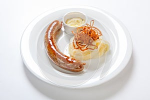 Mashed potato and roasted sausage or bratwurst on white plate