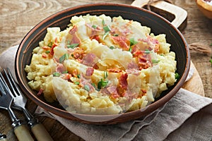 Mashed potatoes. Bacon mashed potatoes with green onion, pepper and cheddar cheese in bowl on old wooden backgrounds. Delicious