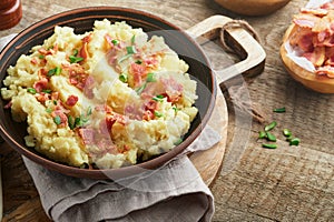 Mashed potatoes. Bacon mashed potatoes with green onion, pepper and cheddar cheese in bowl on old wooden backgrounds. Delicious