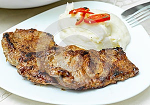 Mashed potatoes and fried beef steak in white plate