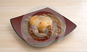 Mashed potatoes with gravy and beef tips on a plate