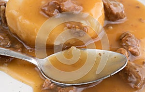 Mashed potatoes with gravy and beef tips with a spoon