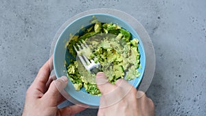 Mashing avocado with fork for guacamole