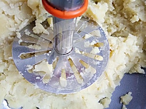 Mashing potato in a bowl.