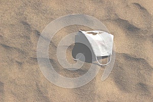 Mask on a beach. Pandemic concept. Environmental and coastal pollution during a pandemic.