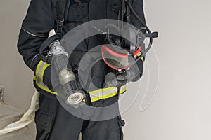 Mask and equipment in the hands of a firefighter, front view