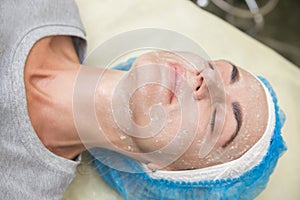 Mask for the face. Woman in a beauty salon makes a mask.