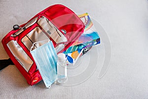 Mask and hand sanitizer on a Children`s backpack