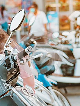 A mask hanging on a motorcycle handle to prevent germs Covid-19 on roadside in the city.