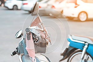 A mask hanging on a motorcycle handle to prevent germs Covid-19 on roadside in the city.