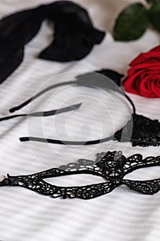 Mask stockings and a hair band for sexual play are lying on bed photo
