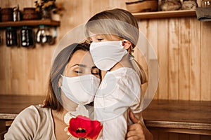 Masked happy and healthy mom and daughter in quarantine. Self isolation. Mother`s day at home