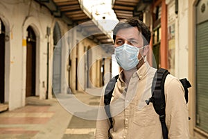 Masked male tourist walks at closed market during coronavirus pandemic, lockdown on Cyprus. Man in mask walks through