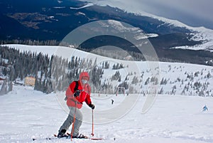 Masked man skier on the route during snow storm