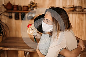 Masked mom hugs masked son. Happy family in quarantine. Love mom and son