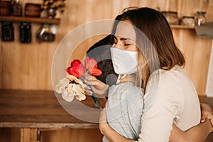 Masked mom hugs masked son. Happy family in quarantine. Love mom and son