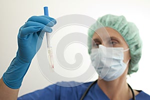 Masked nurse asservating liquid