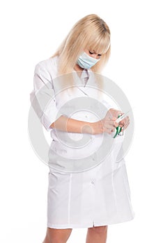 Masked nurse with a syringe in her hand and a stethoscope