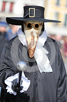 masked person with dark clothes and long beak called Plague doct