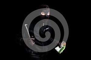 Masked thief in balaclava with crowbar isolated on black