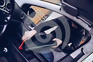 Masked thief in a balaclava stealing laptop computer