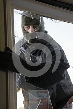 Masked Thief Breaking In Through Window photo