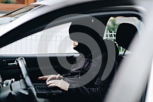 Masked thief hacker in a balaclava disarming car security systems