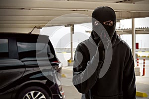 Masked thief trying to steal car