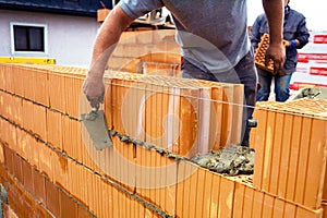 Mason with brick on construction site