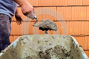 Mason with brick house on construction site