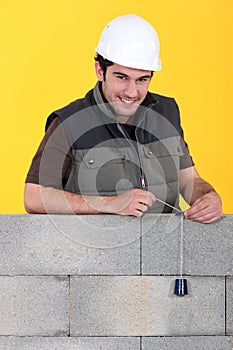 A mason checking his wall
