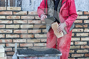 Mason hand spread a mortar on brick