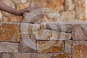 Mason hands working on masonry stone wall