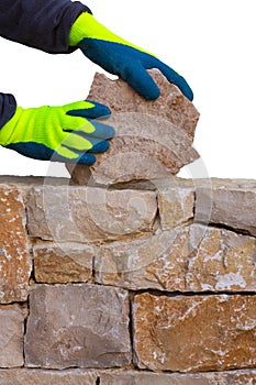 Mason hands working on masonry stone wall