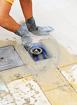 Mason installing a drinking water stopcock on the sidewalk of a street.